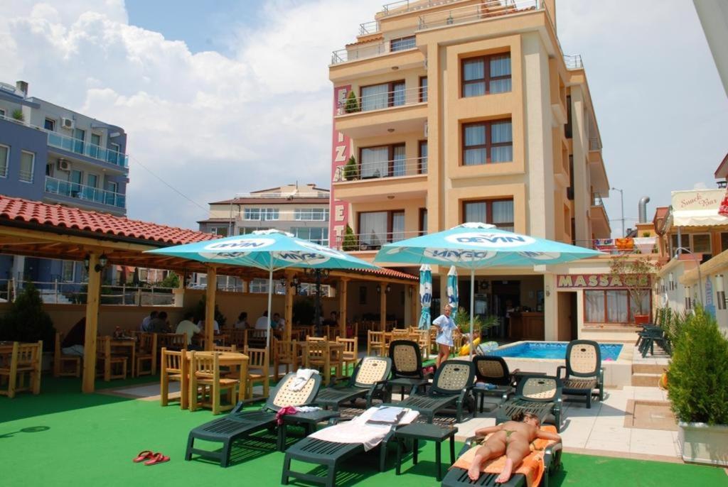 a group of chairs and umbrellas next to a pool at Elizabeth Beach Apartments in Nesebar