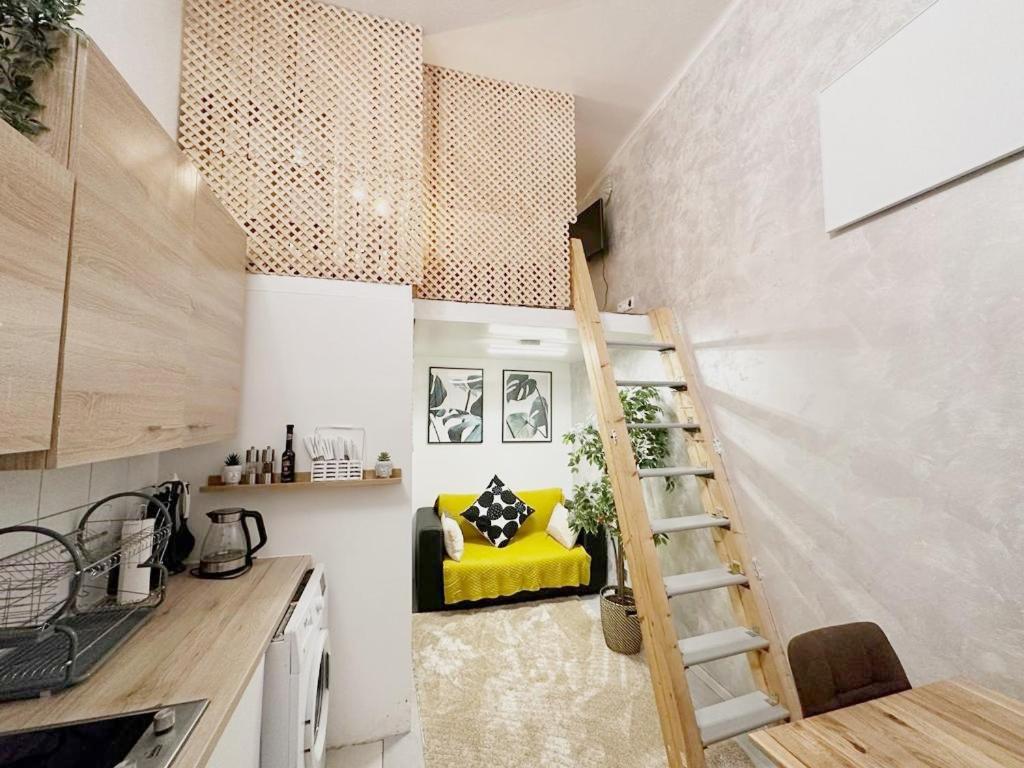 ein Zimmer mit einer Treppe in einer Küche mit einer gelben Bank in der Unterkunft ST Apartment in Wien