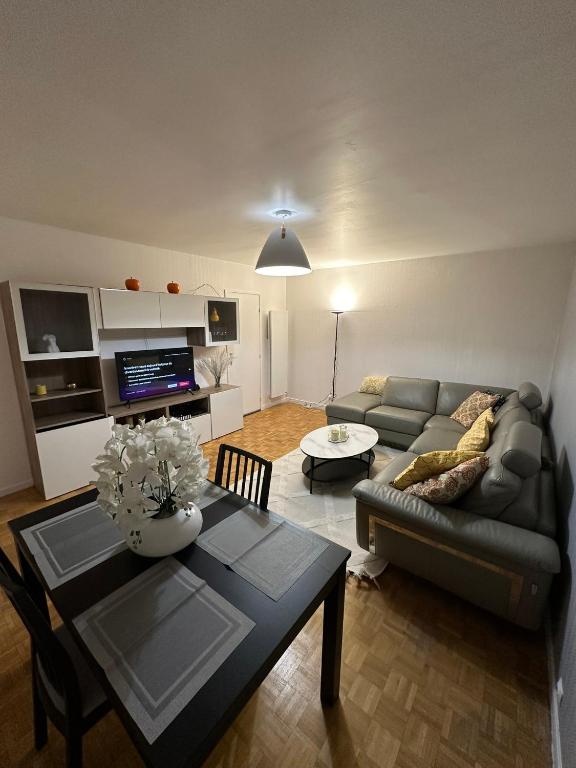 un salon avec un canapé et une table dans l'établissement Appartement en résidence- Clichy, à Clichy