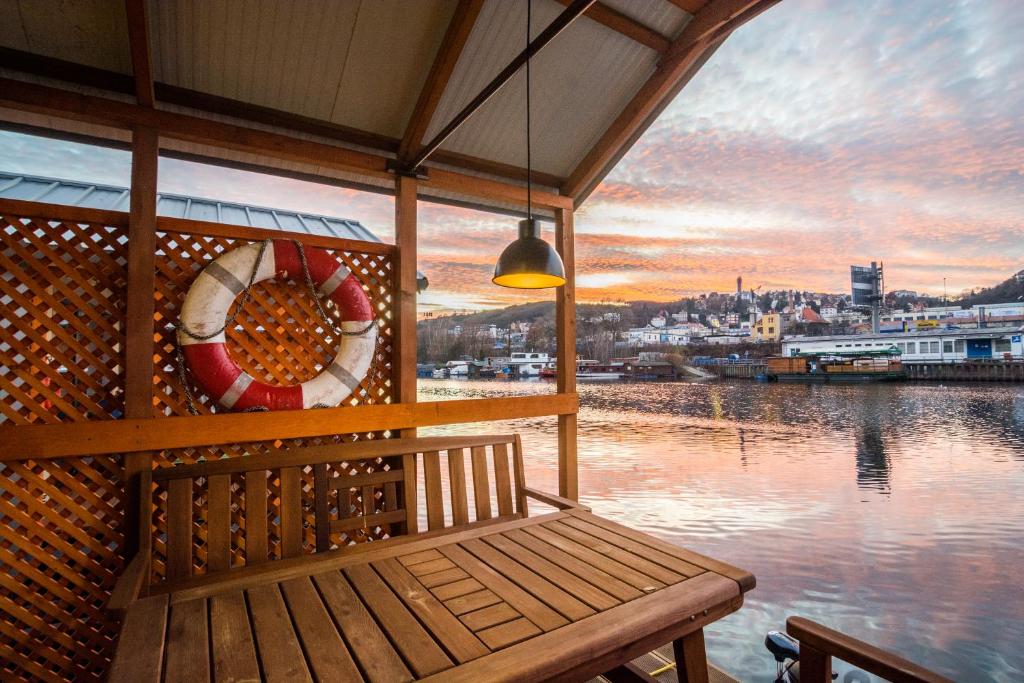 un banc assis sur le côté d'une masse d'eau dans l'établissement Houseboat Franklin - Houseboats Benjamin & Franklin, à Prague