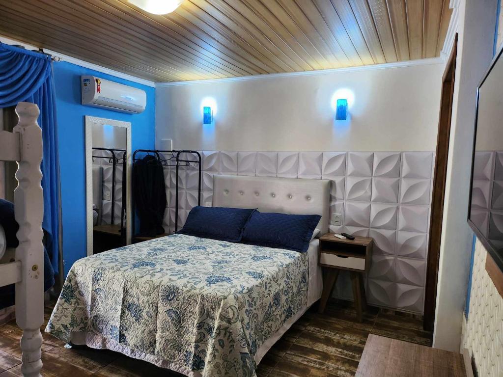 1 dormitorio con 1 cama con luces azules en la pared en Beto Pousada, en Penha