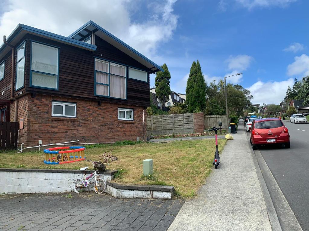 um carro vermelho estacionado em frente a uma casa em Sunny holiday home Wellington em Wellington
