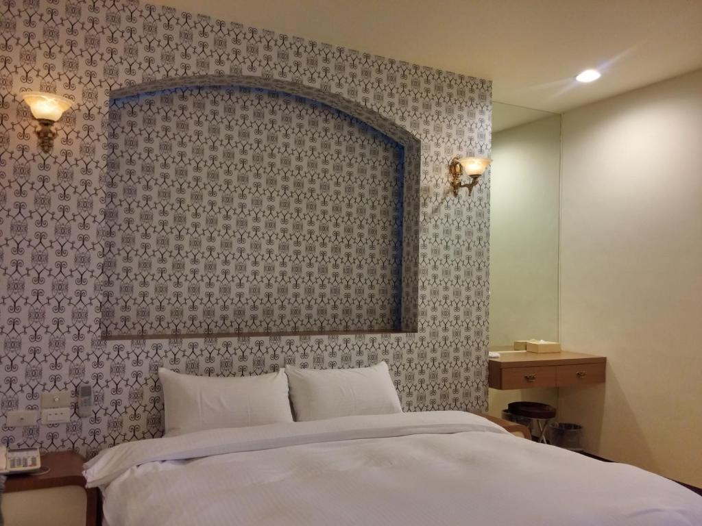 a bedroom with a bed and a wall with a mirror at Foot Track Bed and Breakfast in Hualien City