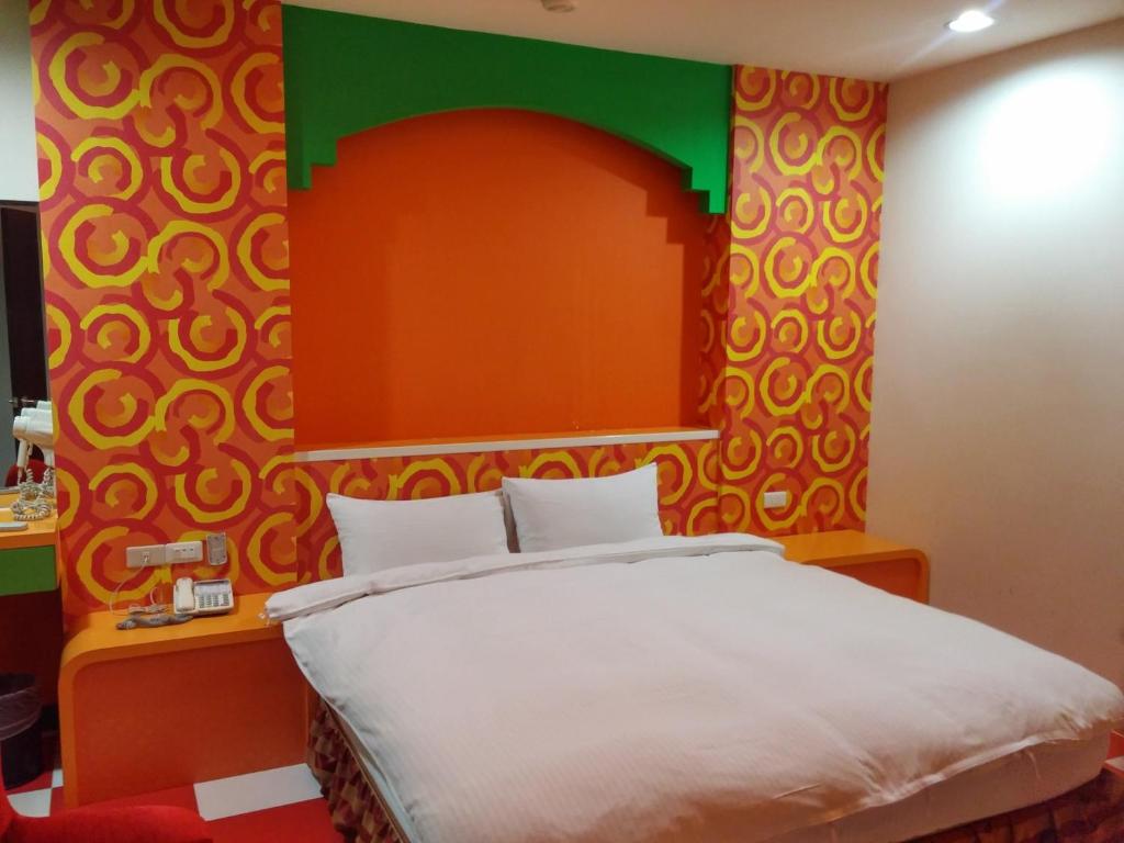 a bedroom with a bed and a colorful wall at Foot Track Bed and Breakfast in Hualien City