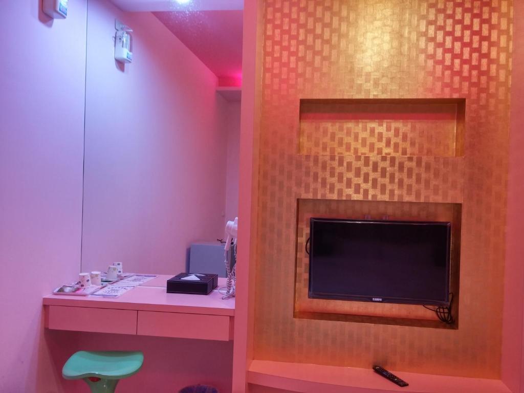 a bathroom with a tv on a wall at Foot Track Bed and Breakfast in Hualien City
