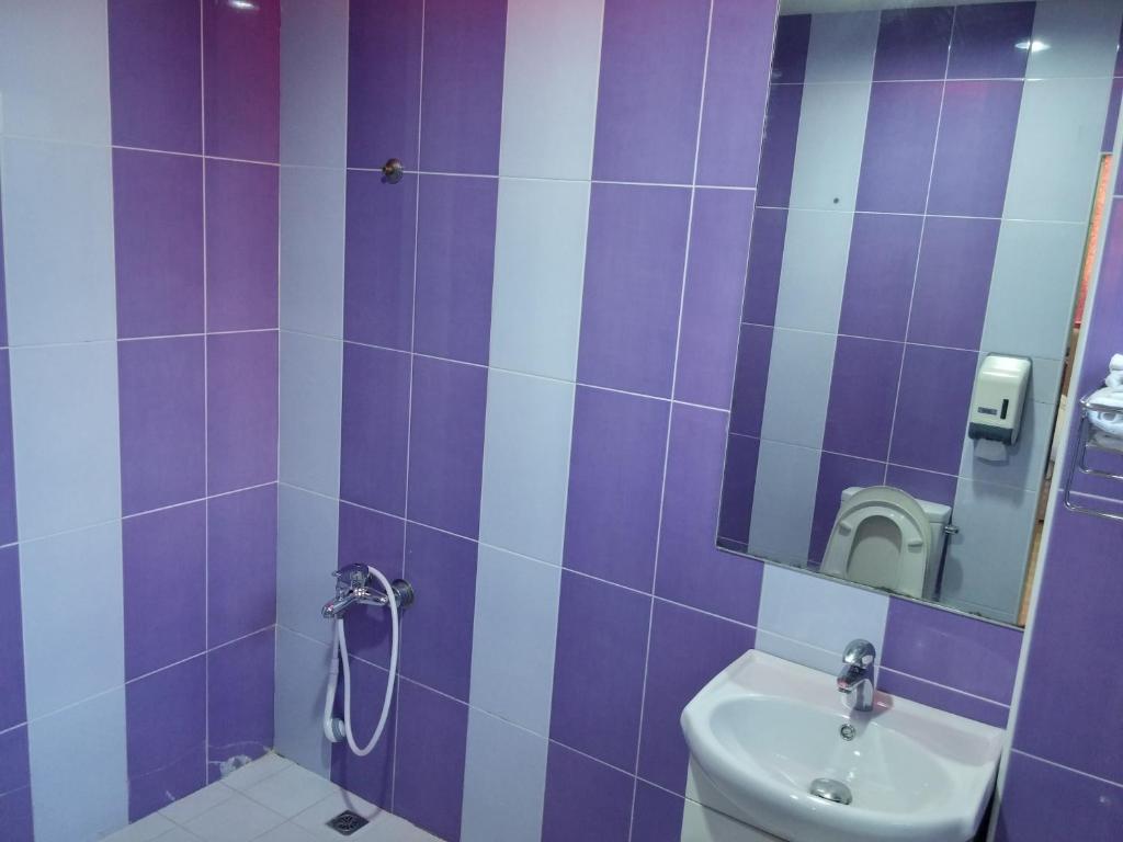 a purple and white bathroom with a toilet and a sink at Foot Track Bed and Breakfast in Hualien City