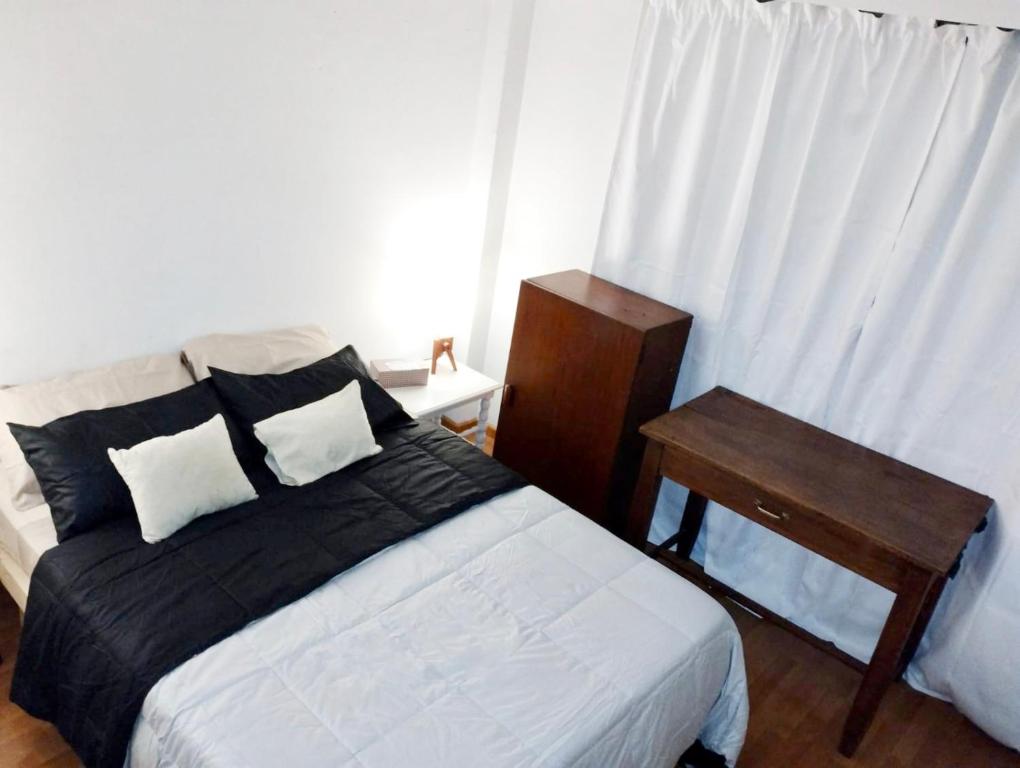 1 dormitorio con cama, mesa y ventana en Abasto, departamento completo y práctico en Buenos Aires
