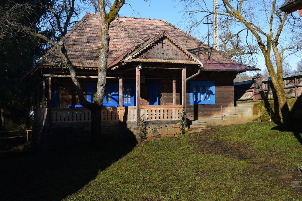 ein kleines Haus mit einer Veranda auf dem Rasen in der Unterkunft Casa Visovan in Sighetu Marmaţiei