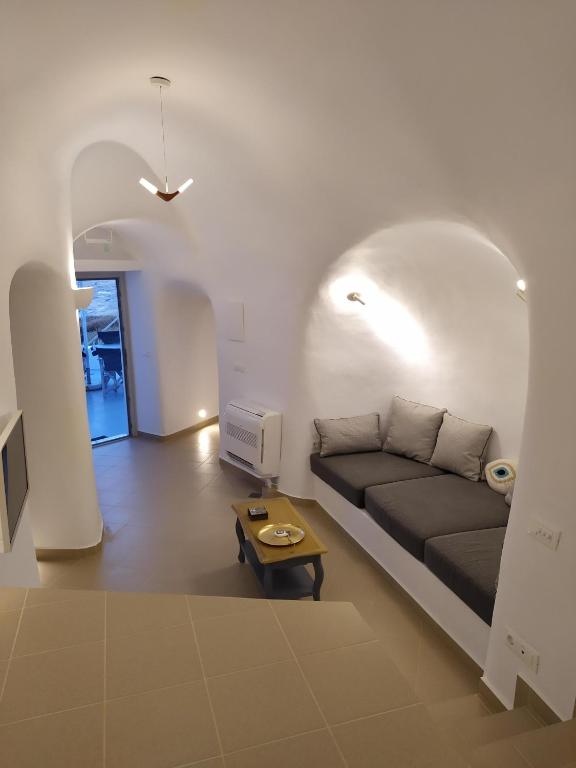 a living room with a couch and a table at Santorini Cave Suite in Éxo Goniá