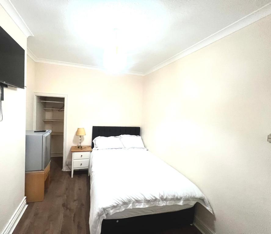 um quarto com uma cama branca e uma televisão em PEACEFUL PLACE em Nottingham