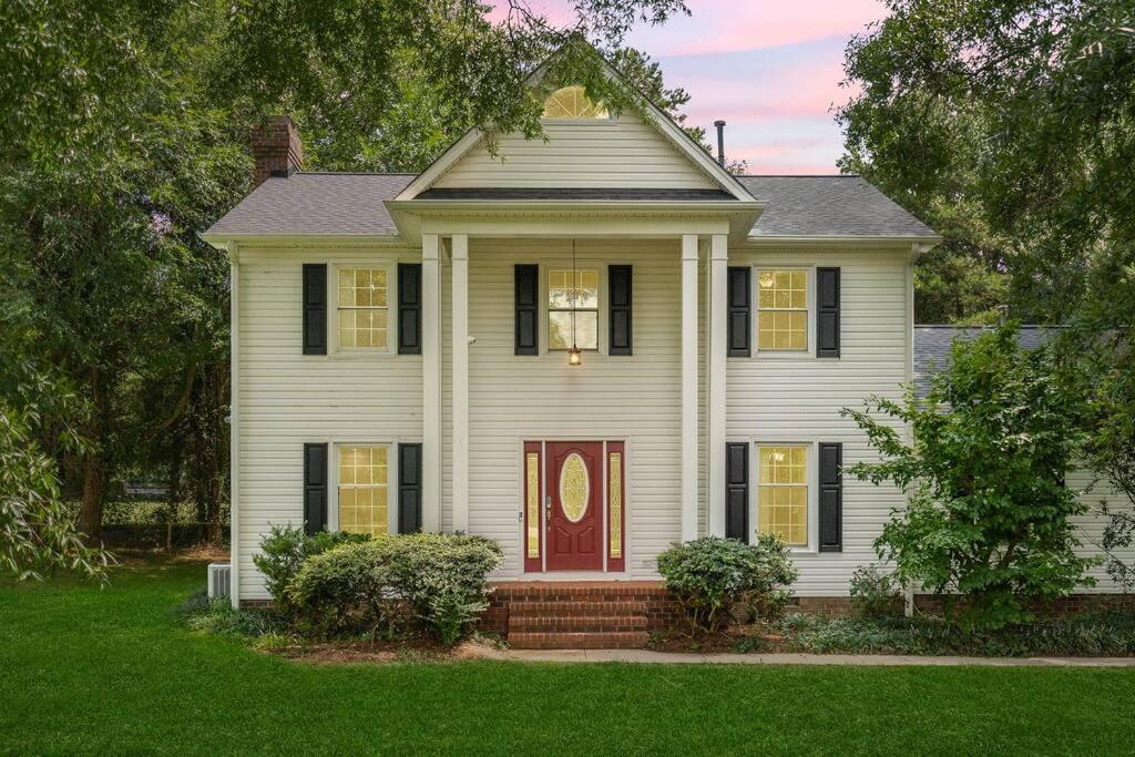 une maison blanche avec une porte rouge et de l'herbe verte dans l'établissement Beautiful Home Walking Distance to Elon University, à Elon