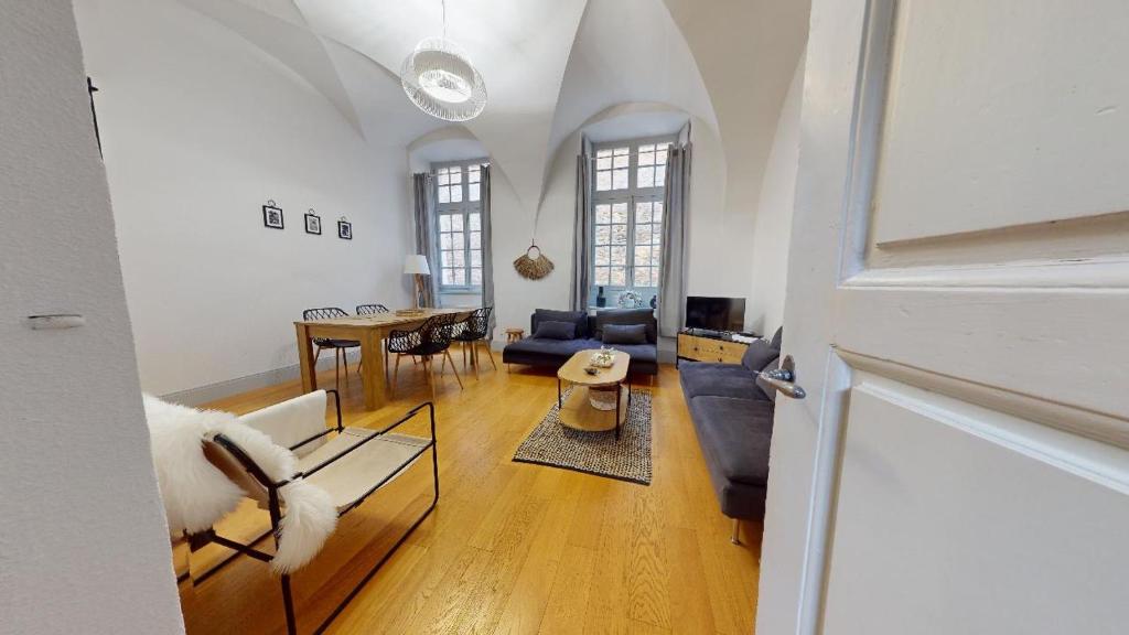 a living room with a couch and a table at Le Prieuré in Dole