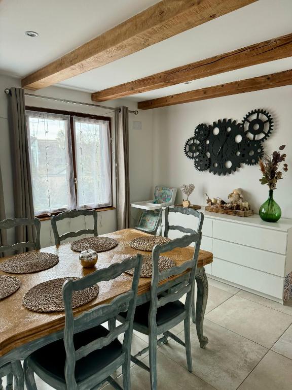 une salle à manger avec une table et des chaises en bois dans l'établissement Duplex au cœur de l’Alsace, à Muttersholtz