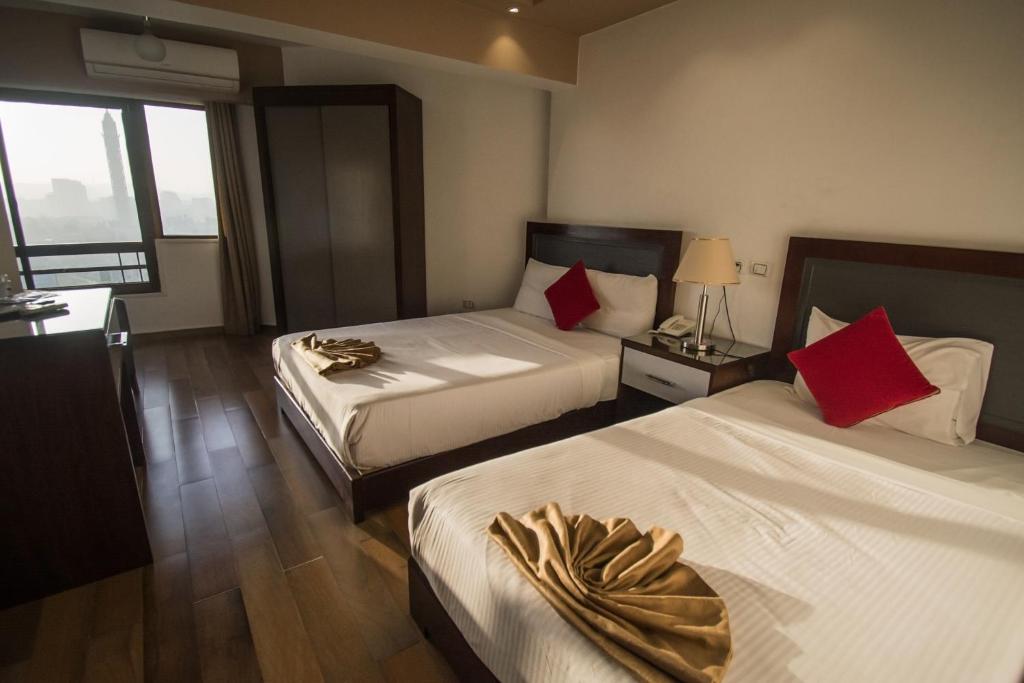 Postel nebo postele na pokoji v ubytování Nile Guardian Hotel
