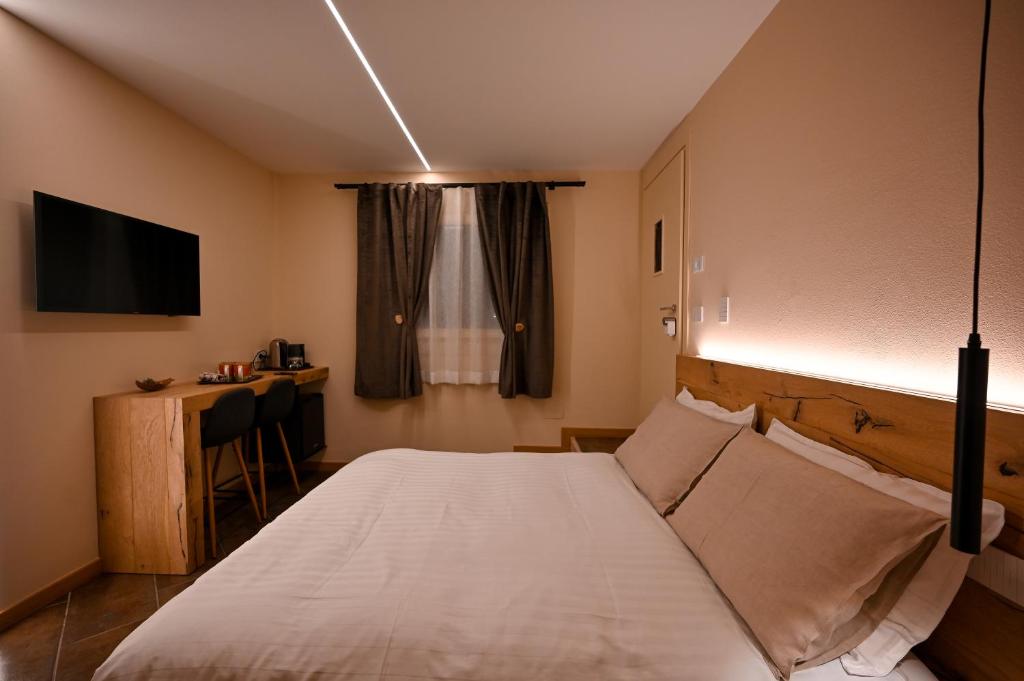Dormitorio con cama, escritorio y TV en Lucalì Mountain Room, en Ponte di Legno