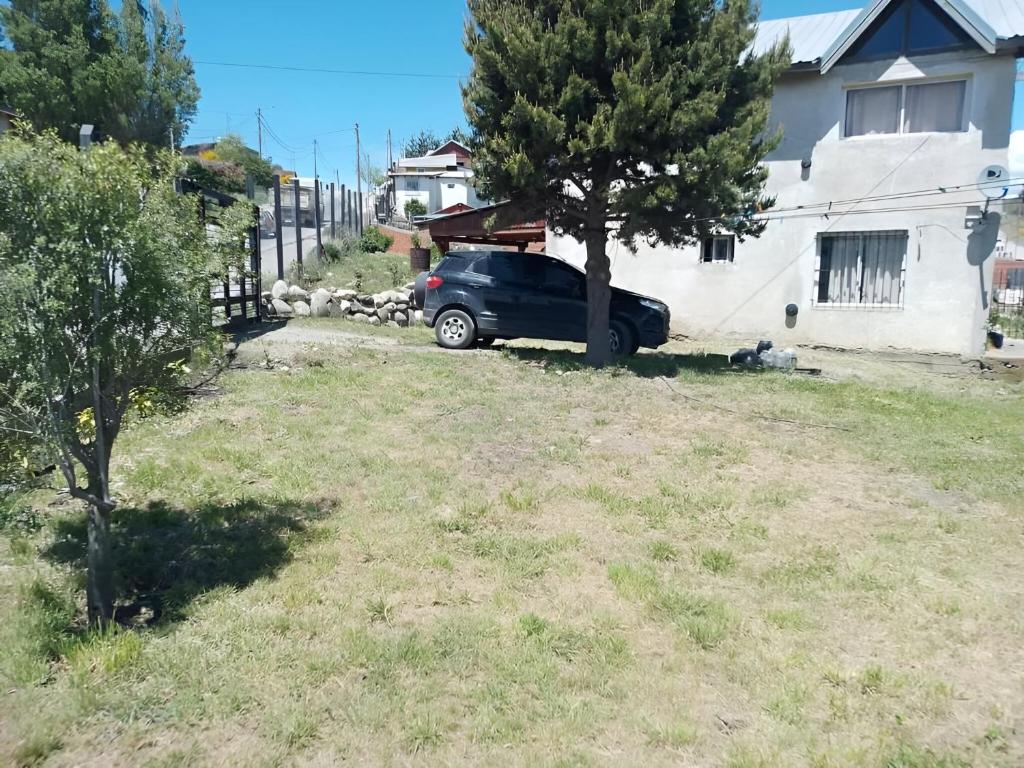 a car parked in a yard next to a house at Casa Maiten 2 dormitorios in San Carlos de Bariloche