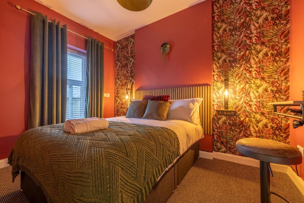 sypialnia z czerwonymi ścianami, łóżkiem i oknem w obiekcie Violet Suite Apartments w mieście Londonderry/Derry
