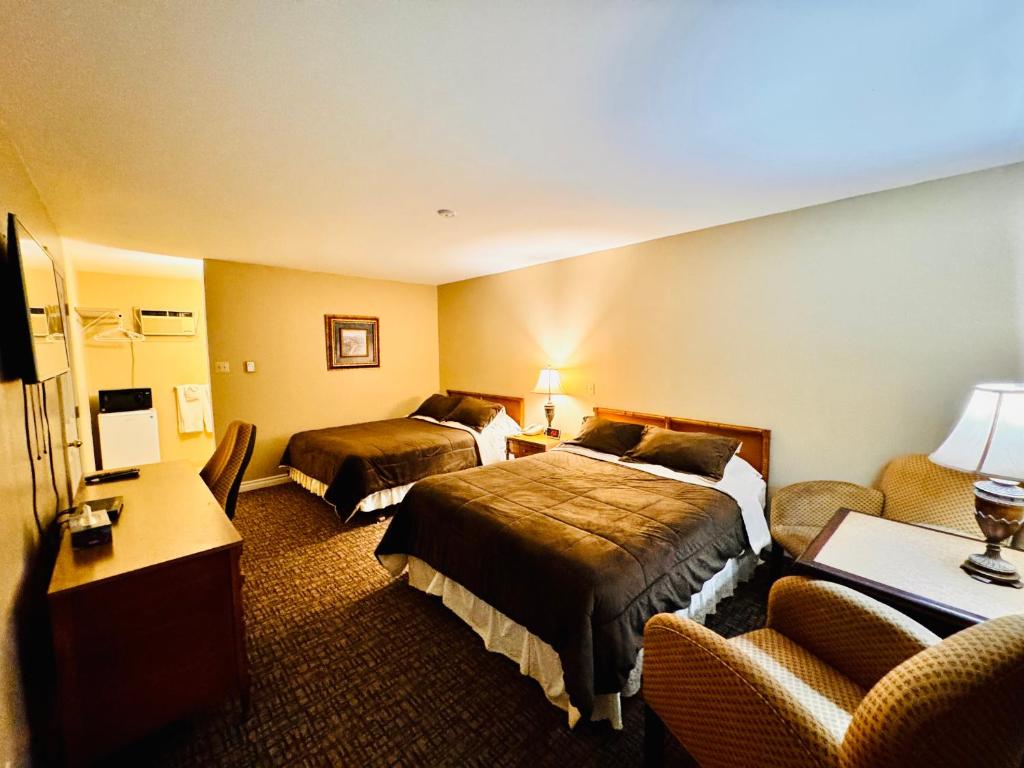 une chambre d'hôtel avec deux lits et un canapé dans l'établissement Fundy Line Motel, à Miramichi