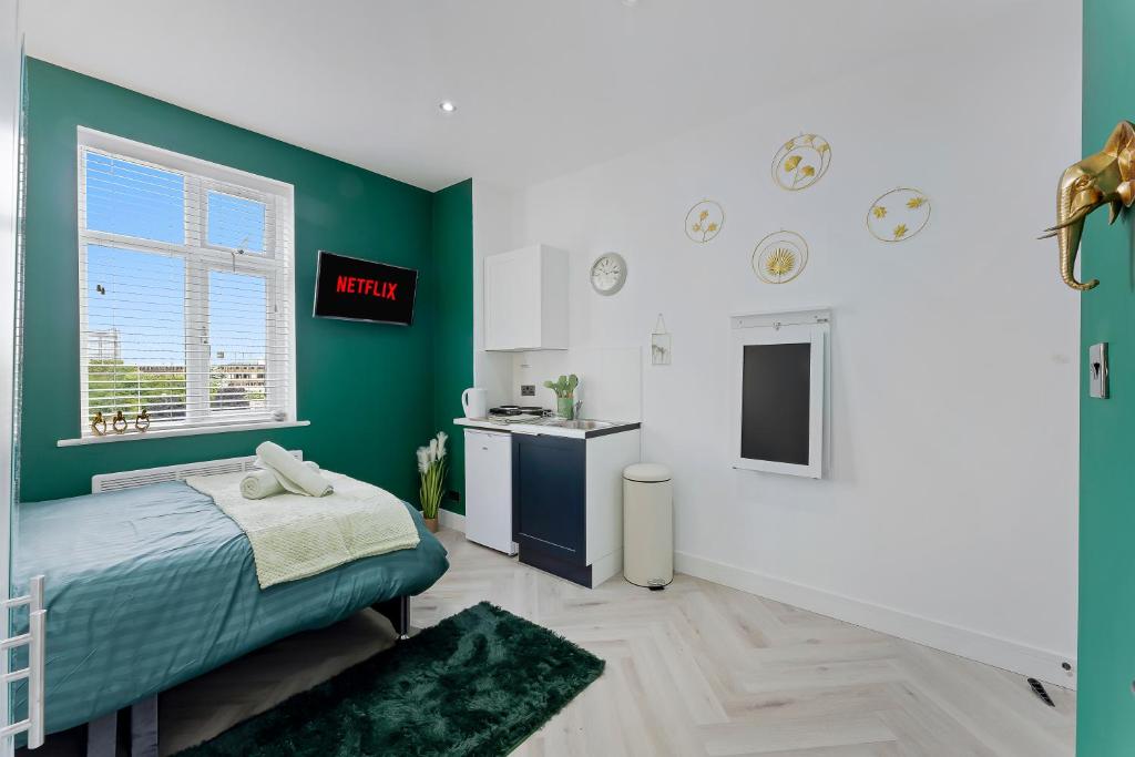 a bedroom with a bed and a green wall at West Five, Double Bedroom Suite with Private Bathroom in London