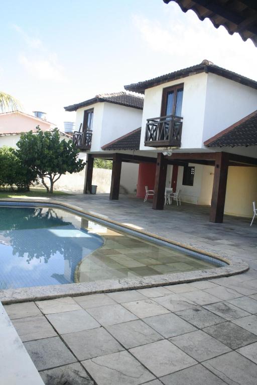 una casa y una piscina frente a una casa en Casa poucos metros do mar Cabo de Sto Agostinho, en Recife