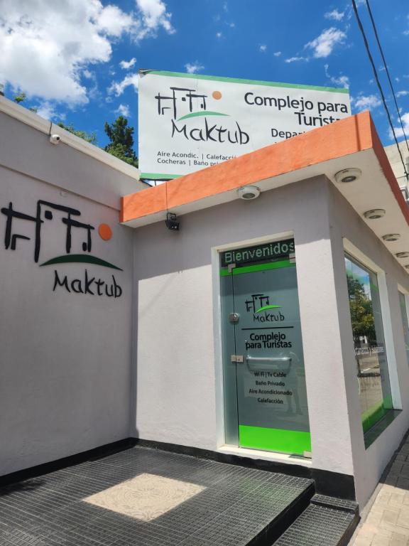 a building with a door and a sign on it at MAKTUB DEPARTAMENTOS Y HABITACIONES in Alta Gracia