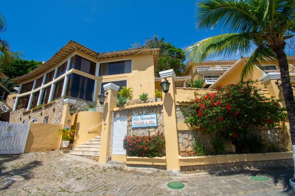 une maison avec un palmier en face dans l'établissement Pousada e Spa Villa Mercedes by Latitud Hoteles, à Búzios