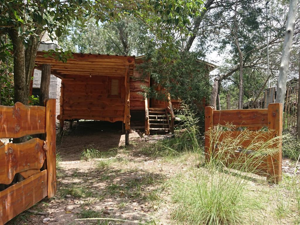 Cabaña de madera con puerta y valla en La Cabañita in 