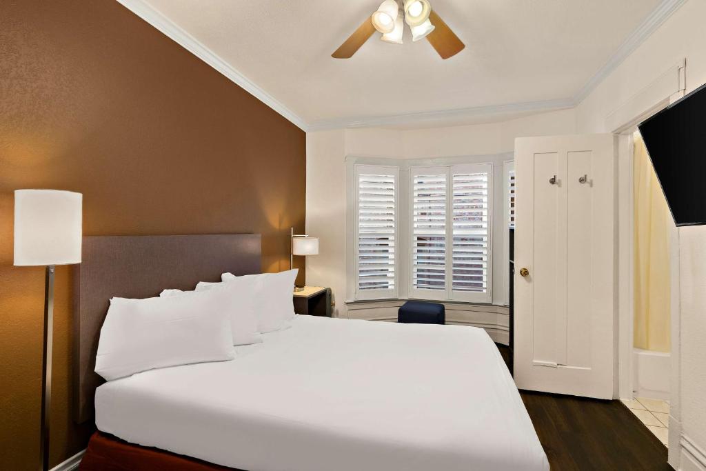 a bedroom with a white bed and a ceiling fan at Mithila San Francisco - SureStay Collection by Best Western in San Francisco