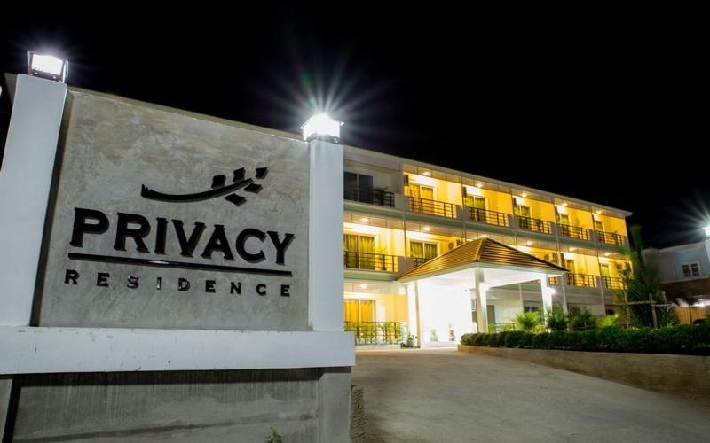 a sign in front of a building at night at Privacy Residence Lopburi in Lop Buri