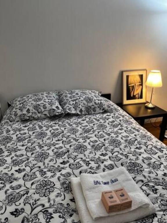 a bed with a black and white comforter with two boxes on it at Eiffel Tower Oasis 30m from Eiffel Tower in Paris