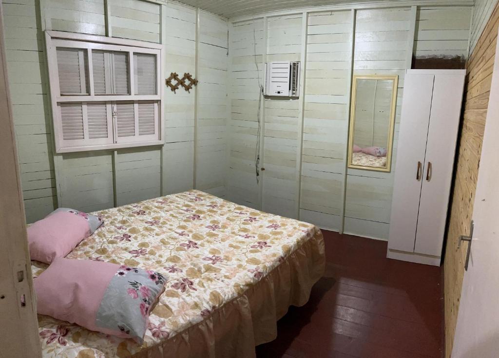 Habitación pequeña con cama y ventana en Casa Ágata, en Cidreira