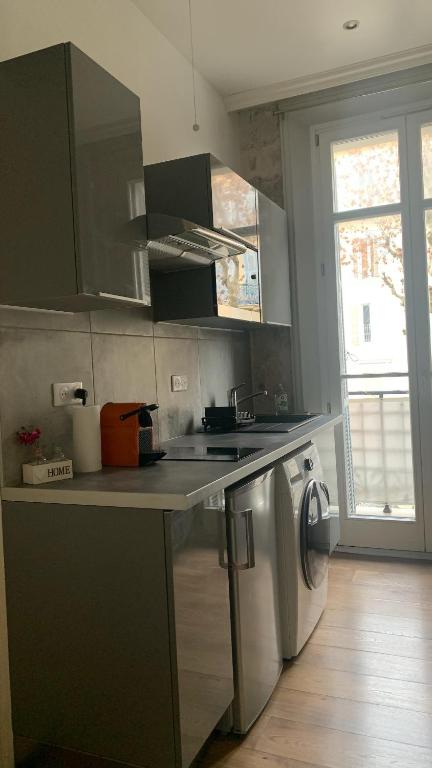 une cuisine avec un évier et une machine à laver dans l'établissement Studio meublé, à Nice