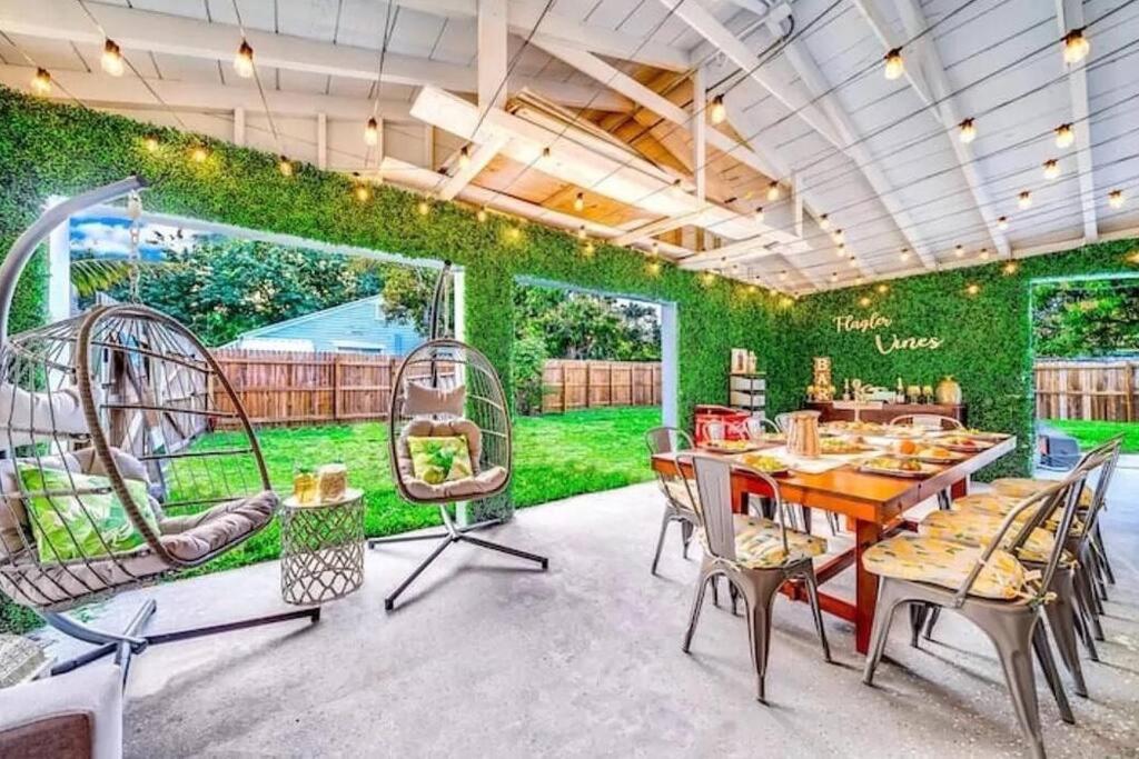 uma sala de jantar com uma parede verde com uma mesa e cadeiras em Rockaway Beach House em West Palm Beach