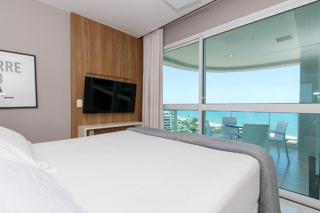 a bedroom with a bed and a large window at Flat Ocean View in Rio de Janeiro