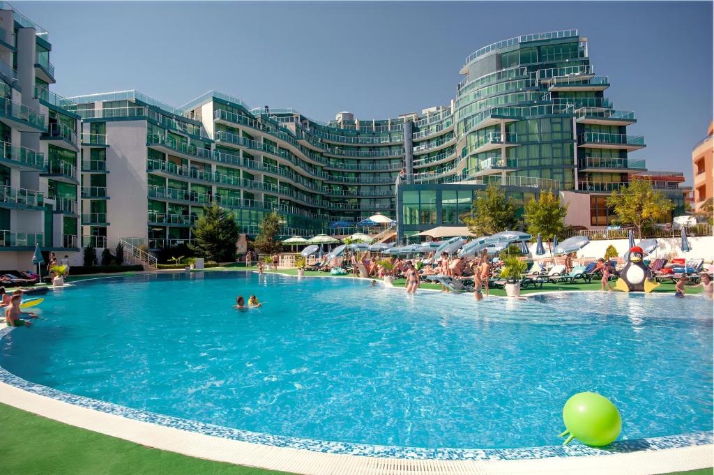 a large swimming pool with people in the water at Paradise Apartments Primorsko in Primorsko