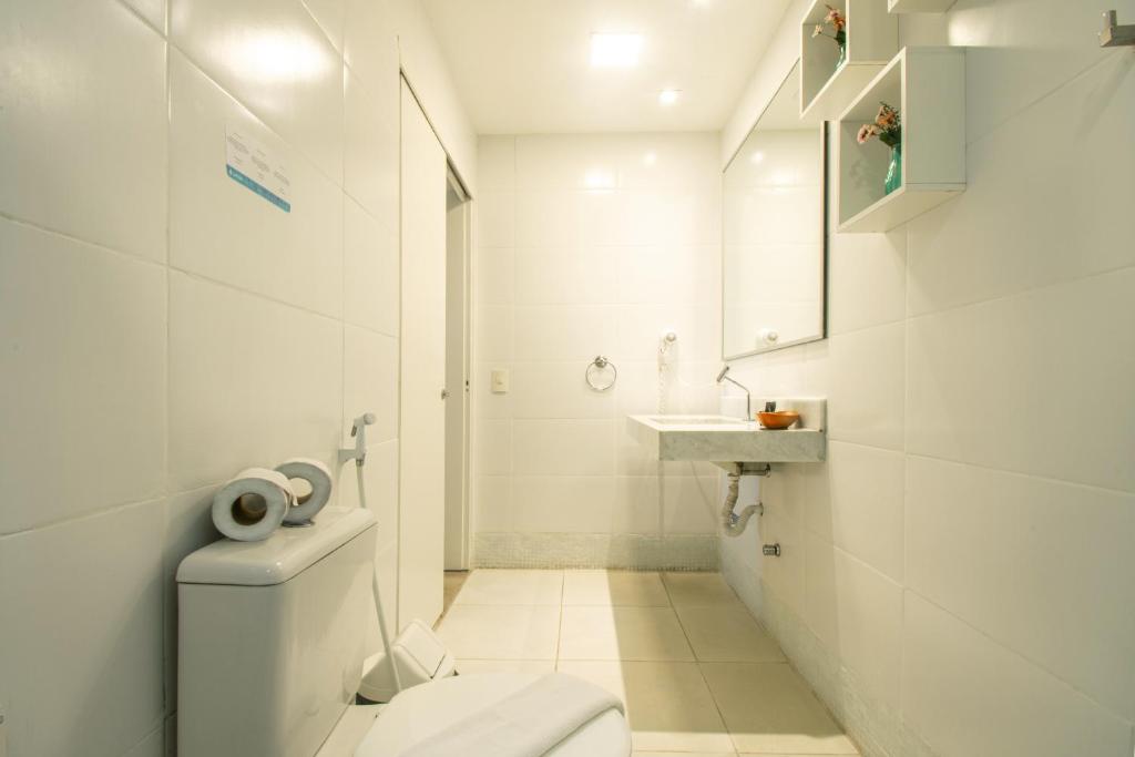 a white bathroom with a toilet and a sink at Pousada Aroma do Mar by Latitud Hoteles in Búzios