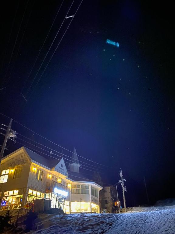 a building with lights on in the snow at night at ロマンスホテル（Romance Hotel） in Nakamachi