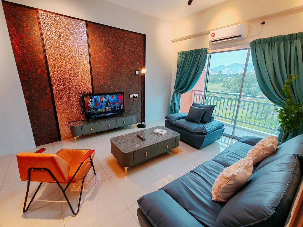 a living room with a blue couch and a television at INS Pavillion by irainbow in Ipoh