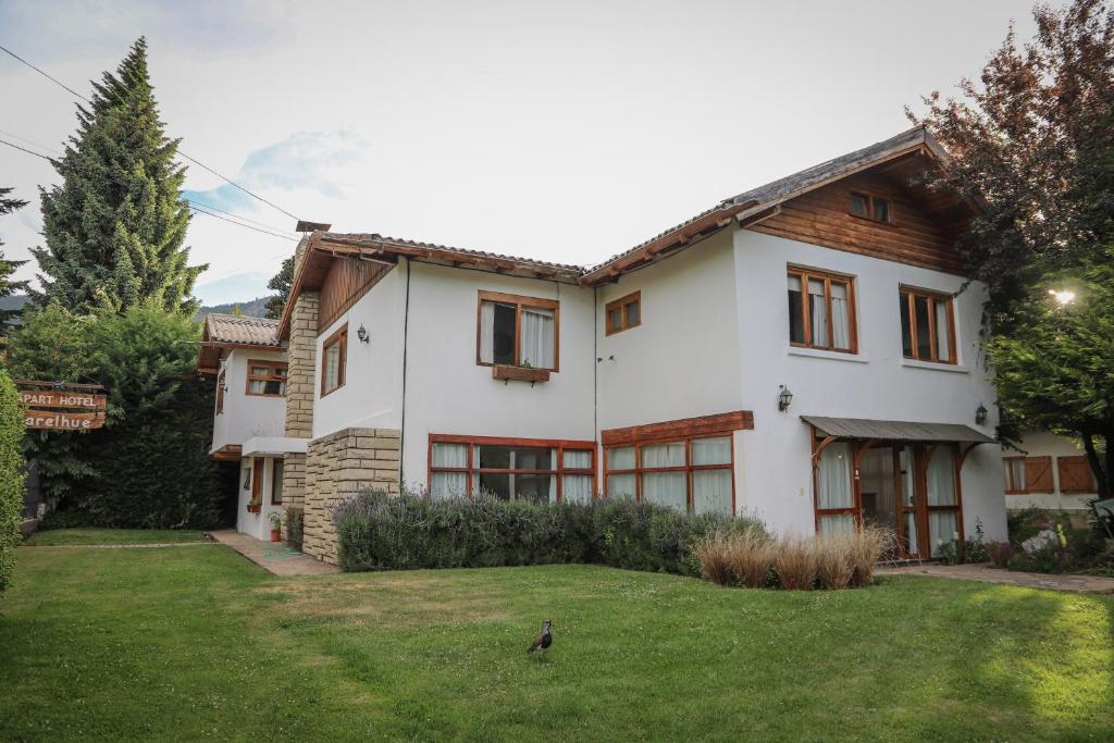 a white house with a bird in the yard at Hostería Carelhue in San Carlos de Bariloche