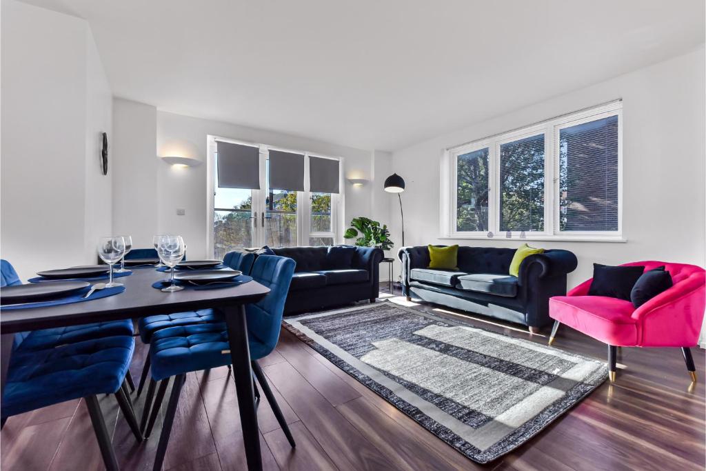 a living room with a table and blue chairs at Charming and Modern 2 BR Flat in London