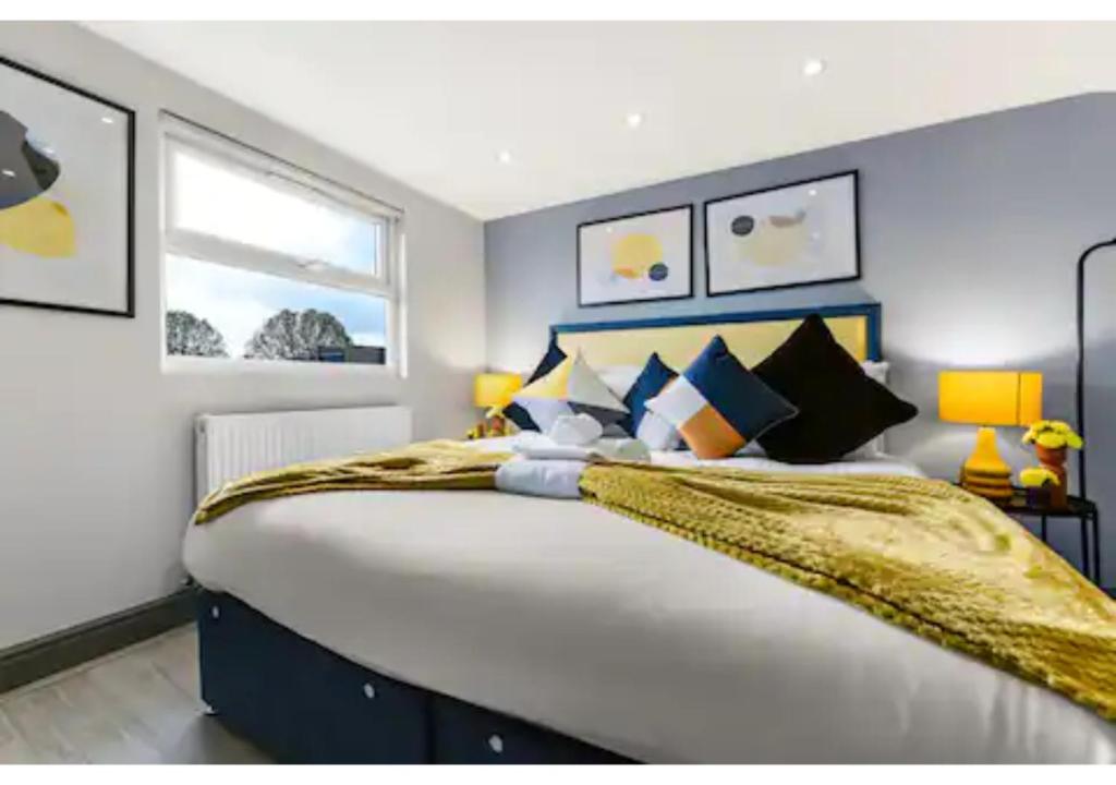 una camera da letto con un grande letto con una coperta gialla di Three Bedroom Home - Perfect for Large Groups a Londra