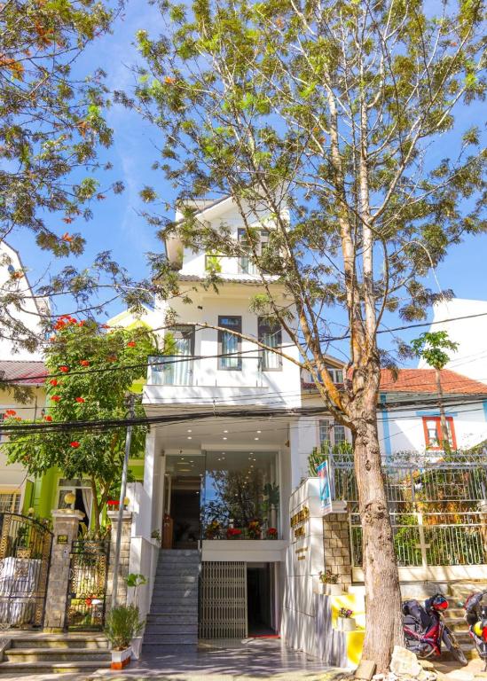 a white house with a tree in front of it at Duy Thảo Hotel in Da Lat