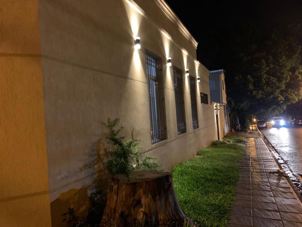 a tree stump sitting next to a building at night at LA SELVA MONOAMBIENTES in Puerto Iguazú