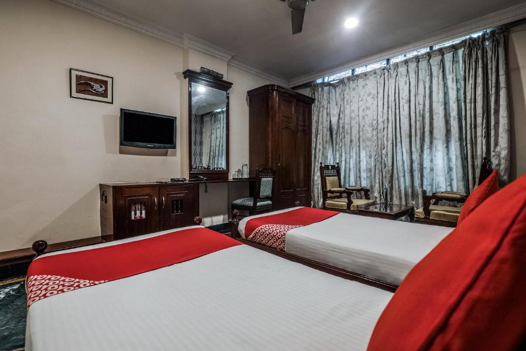 a hotel room with two beds and a television at OYO Athithi Inn Near Hyderabad Central in Ameerpet