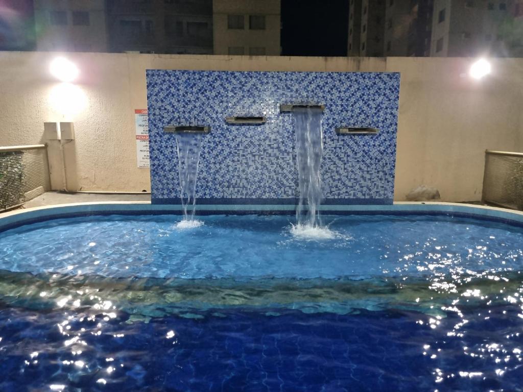 a pool with two water fountains in a building at Residencial Privé das Thermas I in Caldas Novas