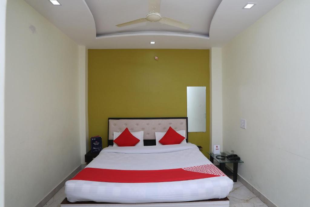 a bedroom with a large bed with red pillows at Hotel Us Residency in Kakarmatha