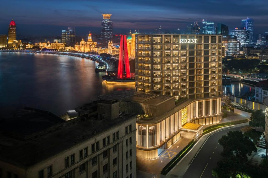 a view of a hotel and a river at night at Regent Shanghai on the Bund in Shanghai