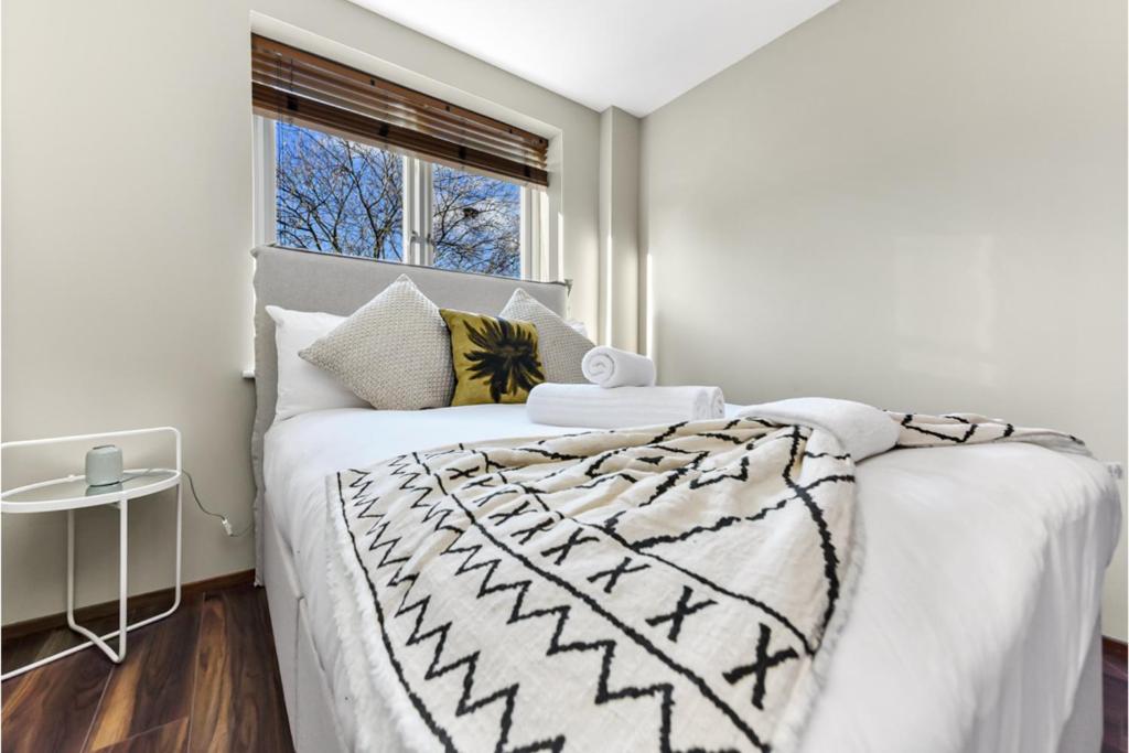 ein Schlafzimmer mit einem weißen Bett und einem Fenster in der Unterkunft Gorgeous Flat, Perfect for Family/Large Group in London