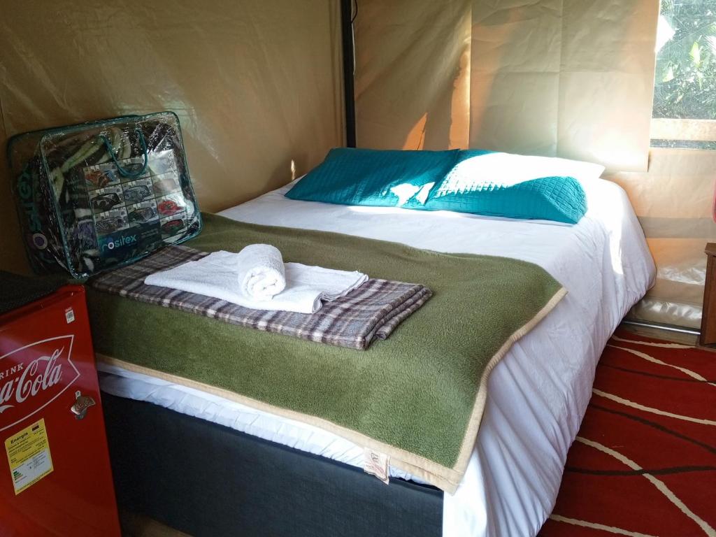 a bed with towels on it in a tent at Glamping Colibrí, ubicado junto a bosque y cercano al parque a la vez in Jardin