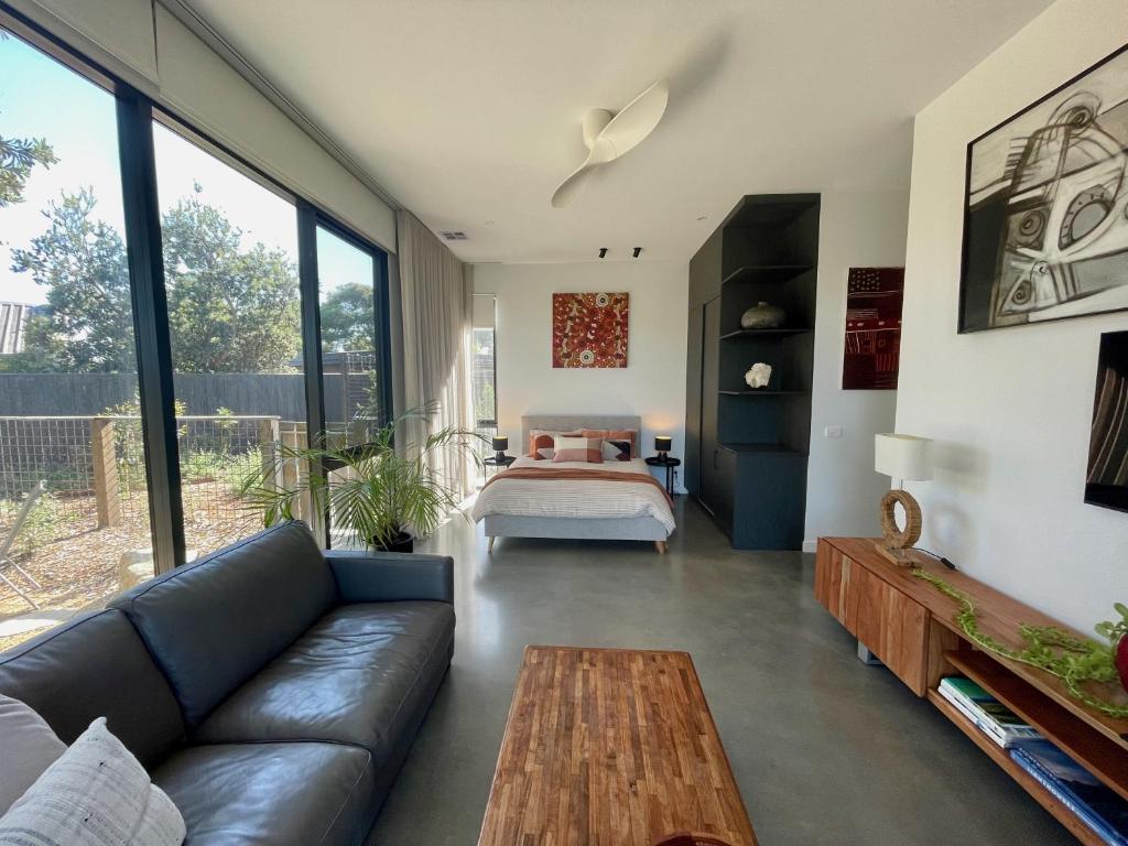 a living room with a couch and a bed at Tanderrum Guest Suite in Point Lonsdale